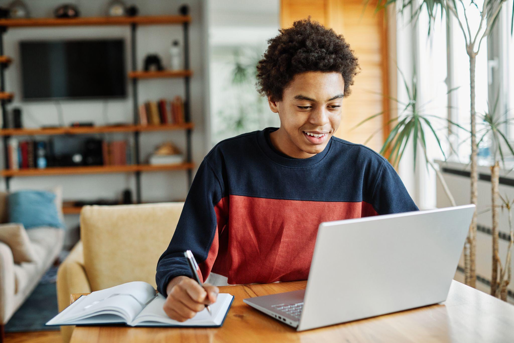Teenage boy using laptop computer at home.