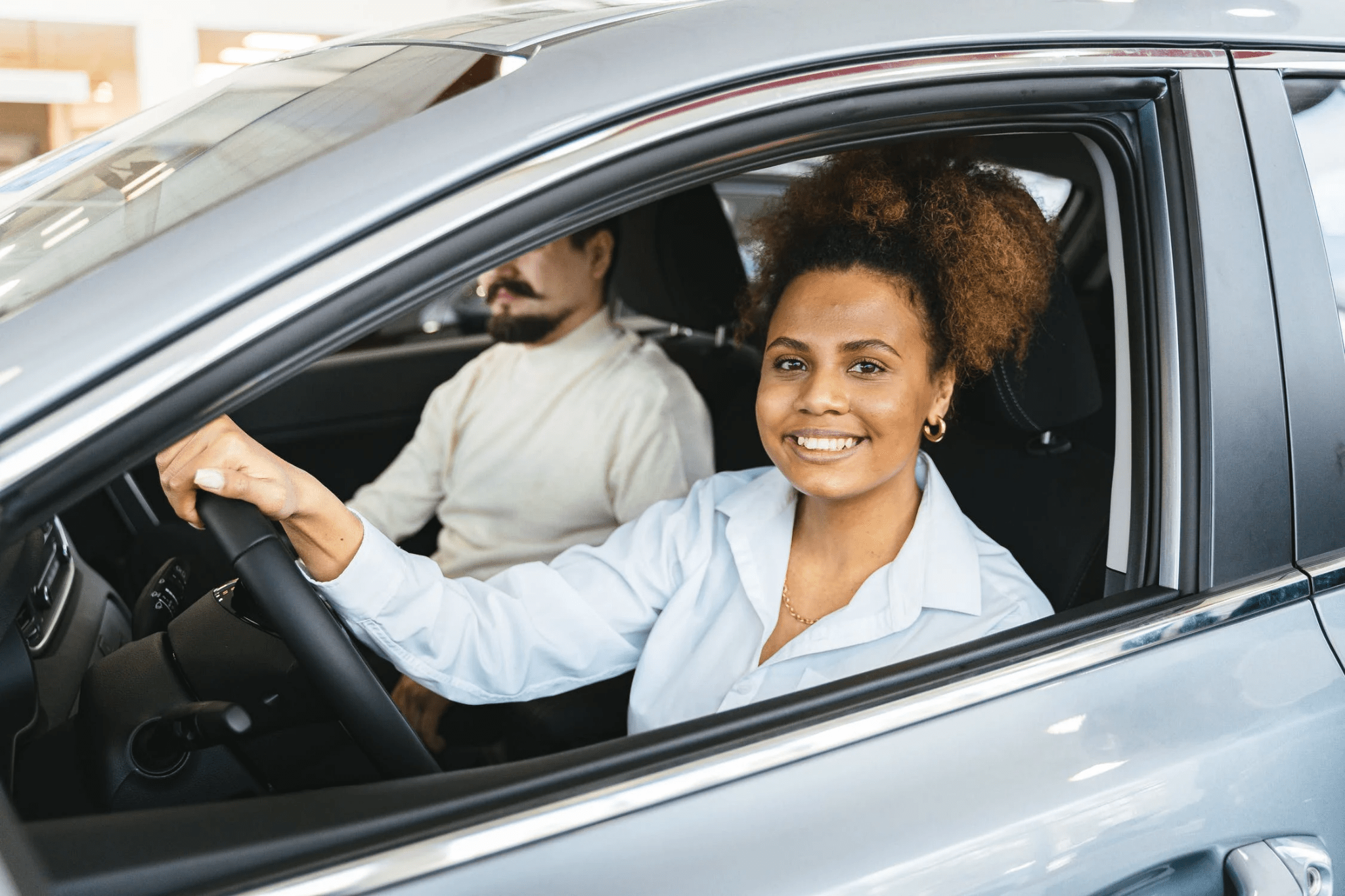 Beautiful female african learner driver with instructor