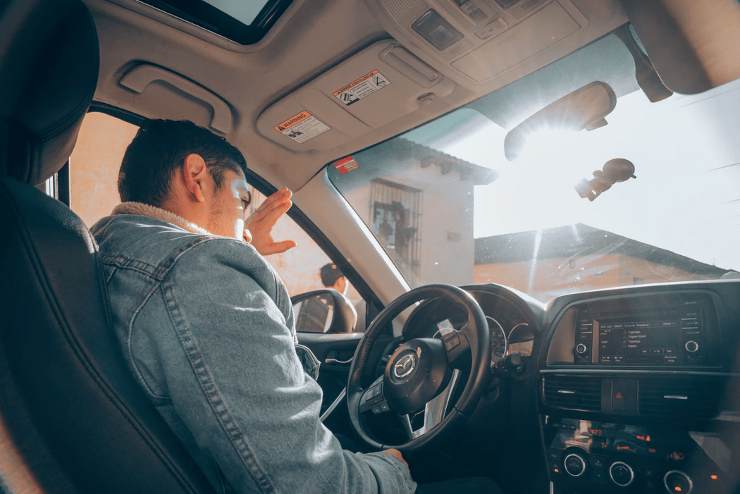 Man driving the car sun reflection in glass