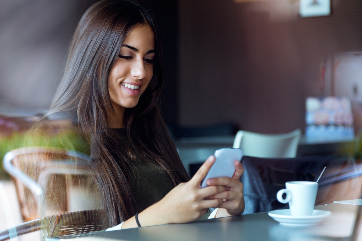 woman is smiling looking smartphone
