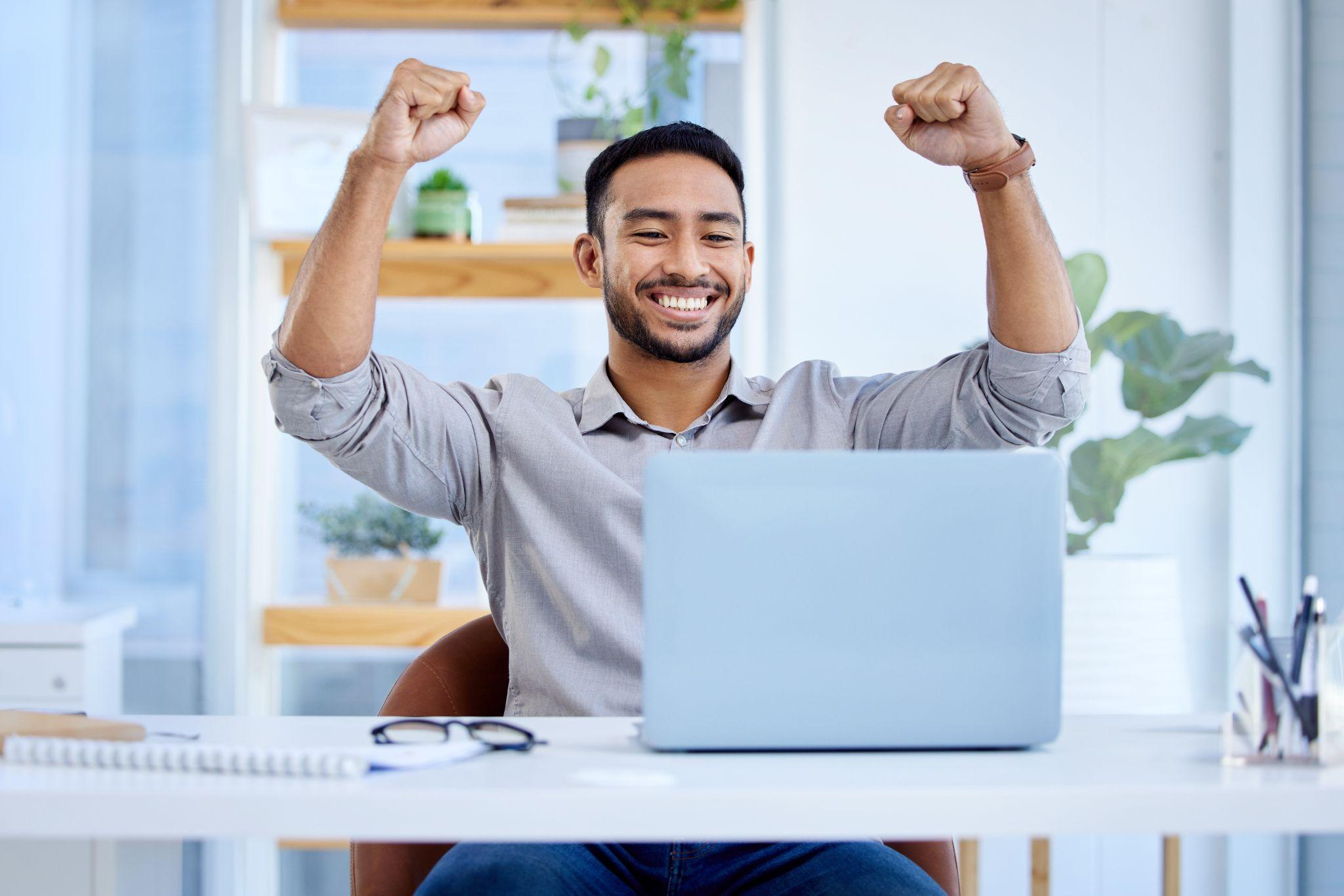 Businessman, laptop and celebrate success or win at desk with fist for bonus deal.