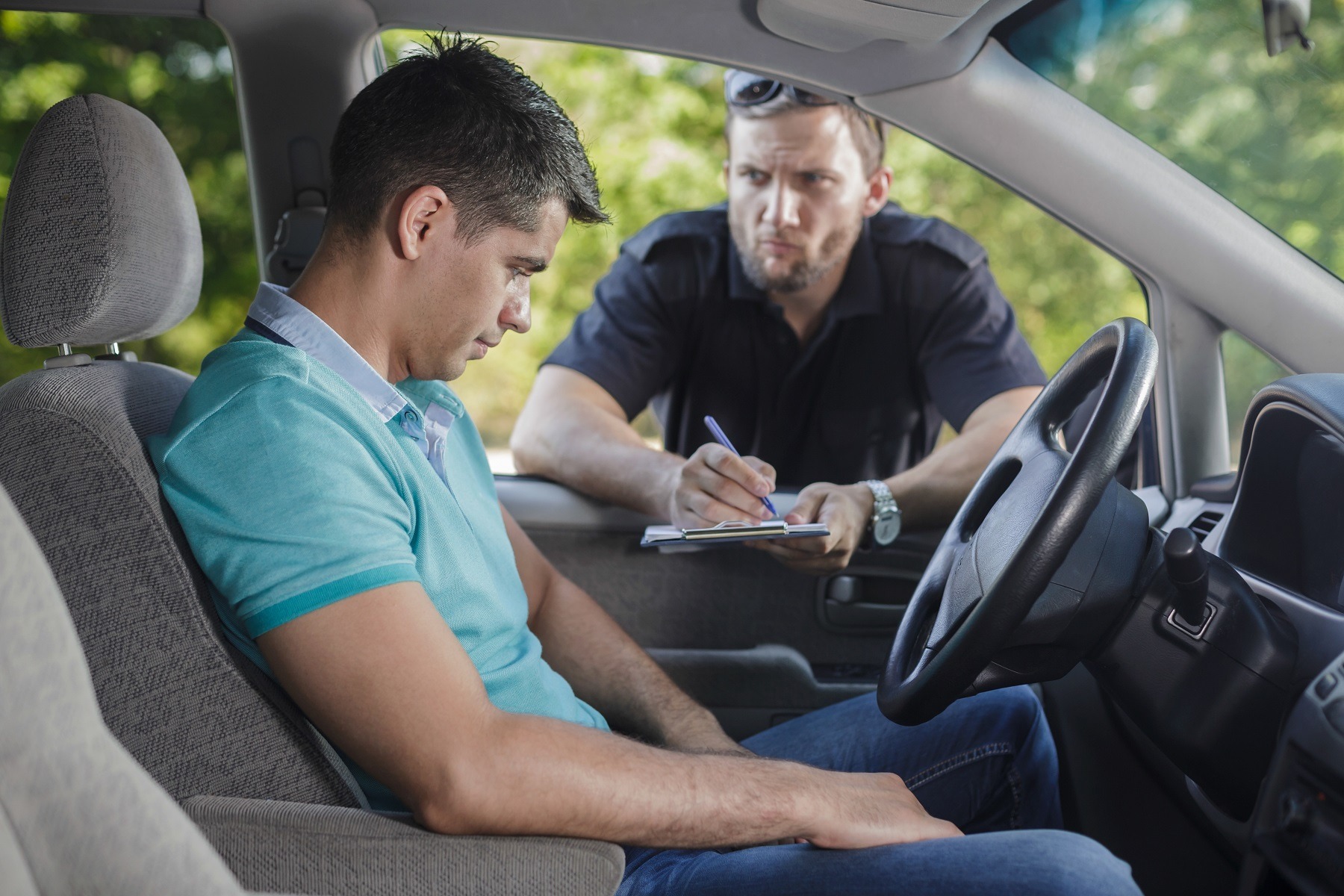Shot of a traffic cop talking to a young driver