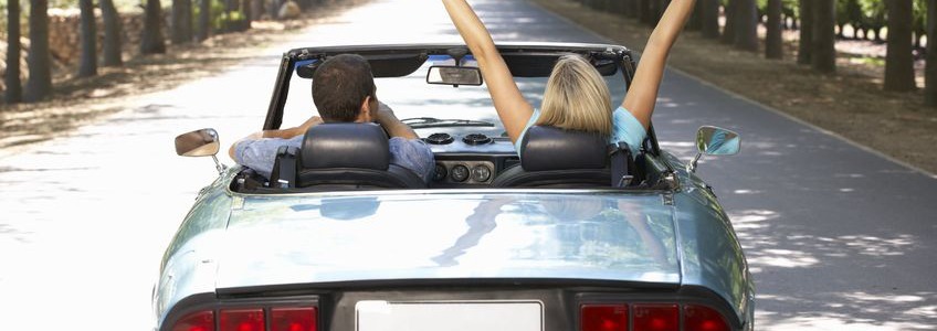 man and woman driving down a road