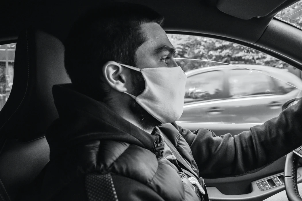 Man driving a car with a mask