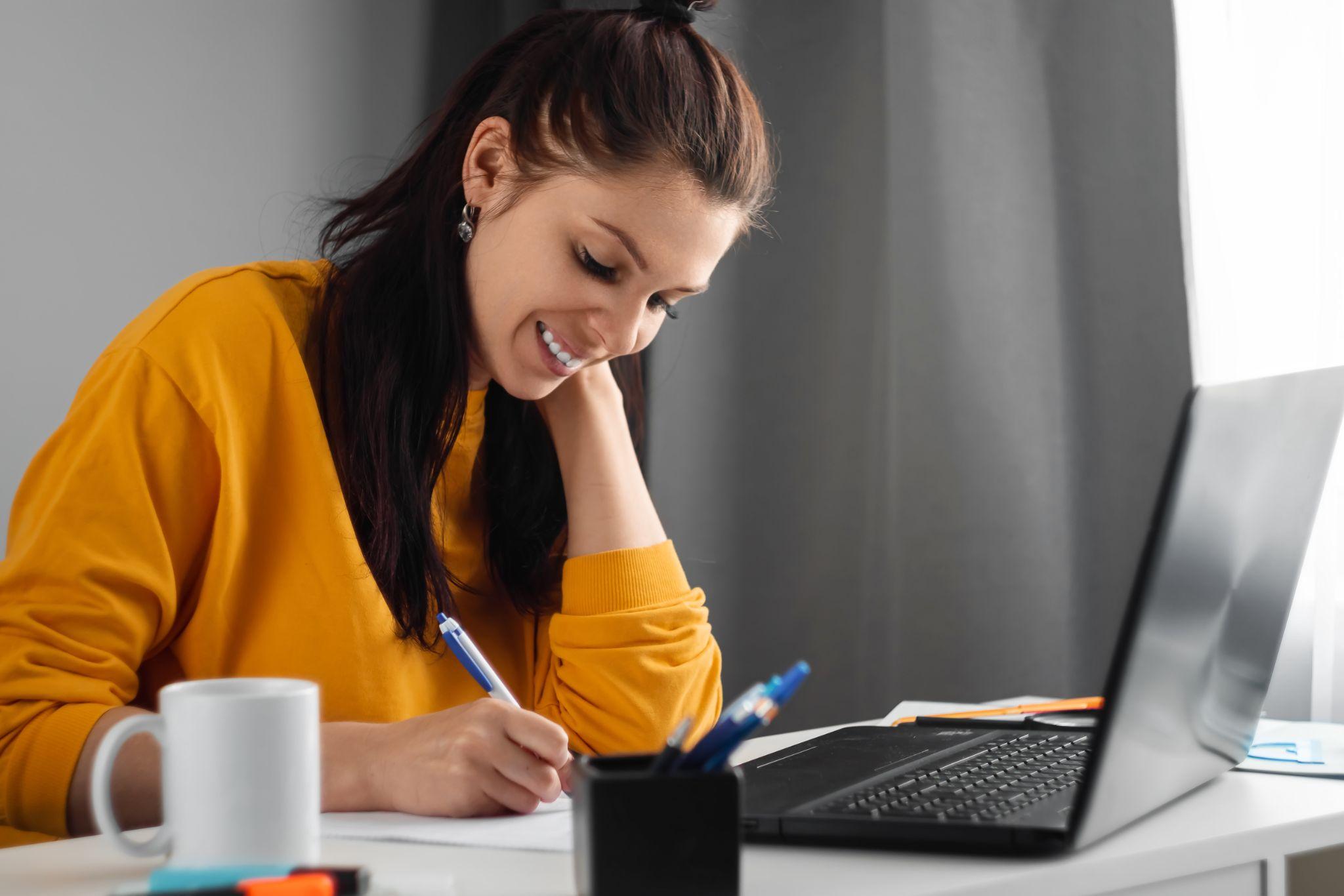 Beautiful girl using laptop studying at home