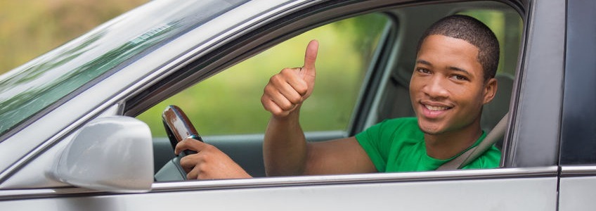 person of color giving a thumbs up out of a car window