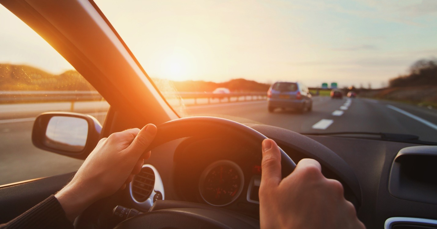driver hands on steering wheel driving on highway road