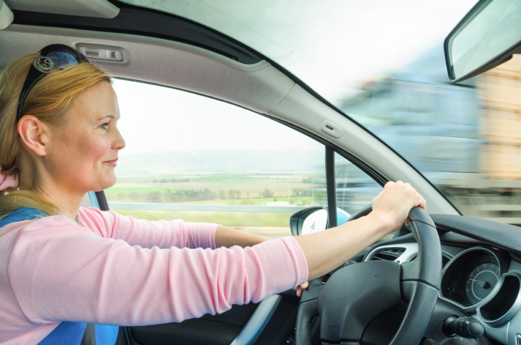 Attractive adult woman safe carefully driving car
