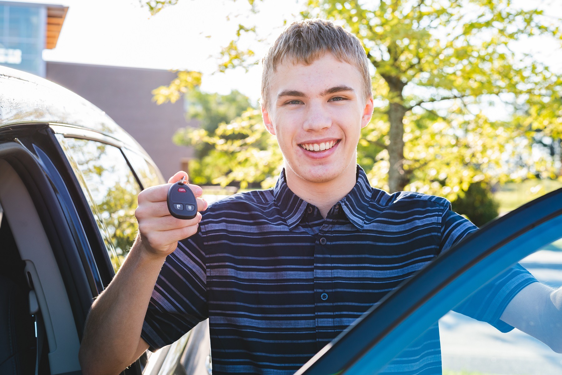 happy teenager showing off his car keys