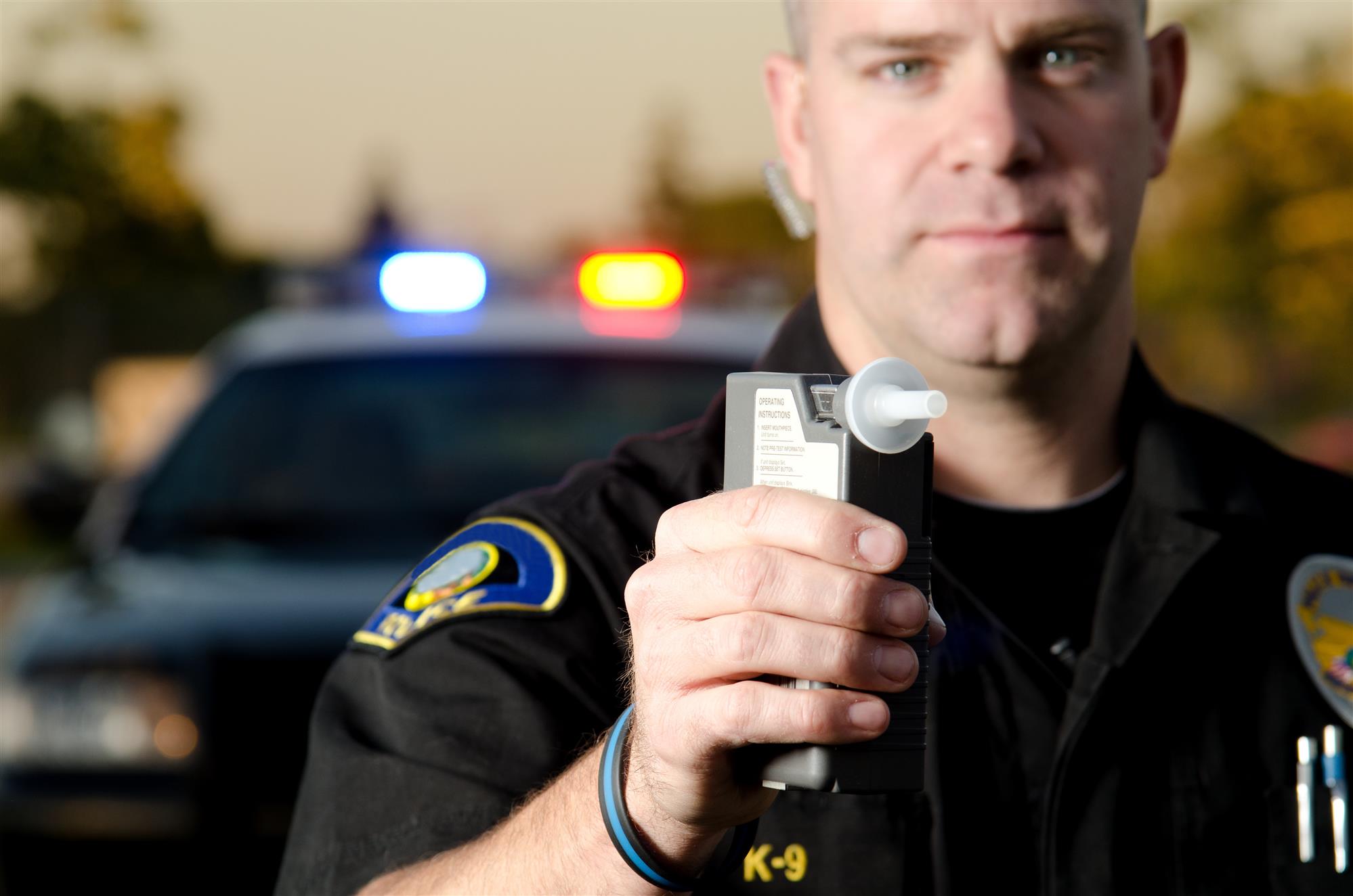 police officer holds a breath test machine
