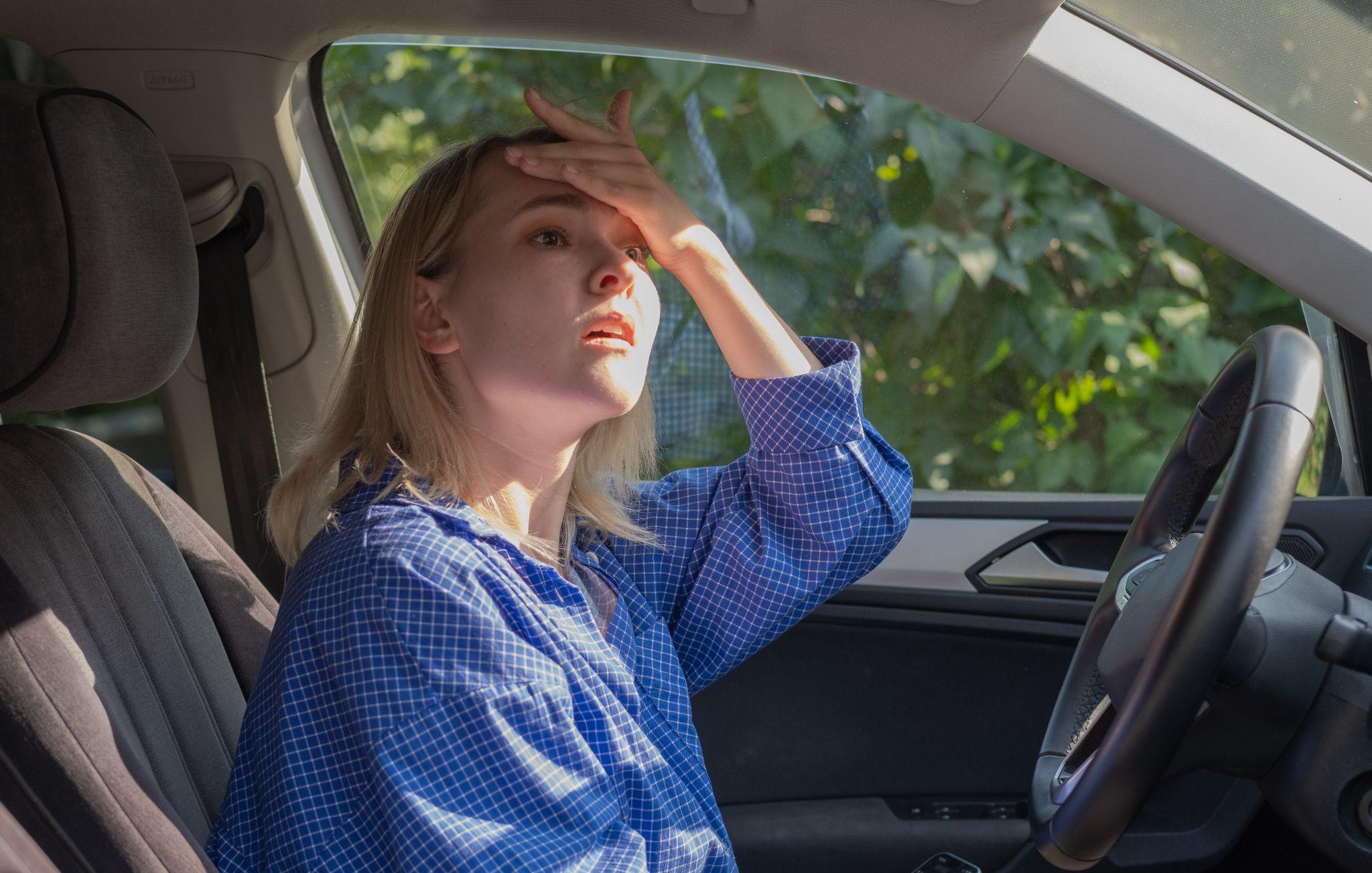 Stressed woman drive car feeling sad and shocked.