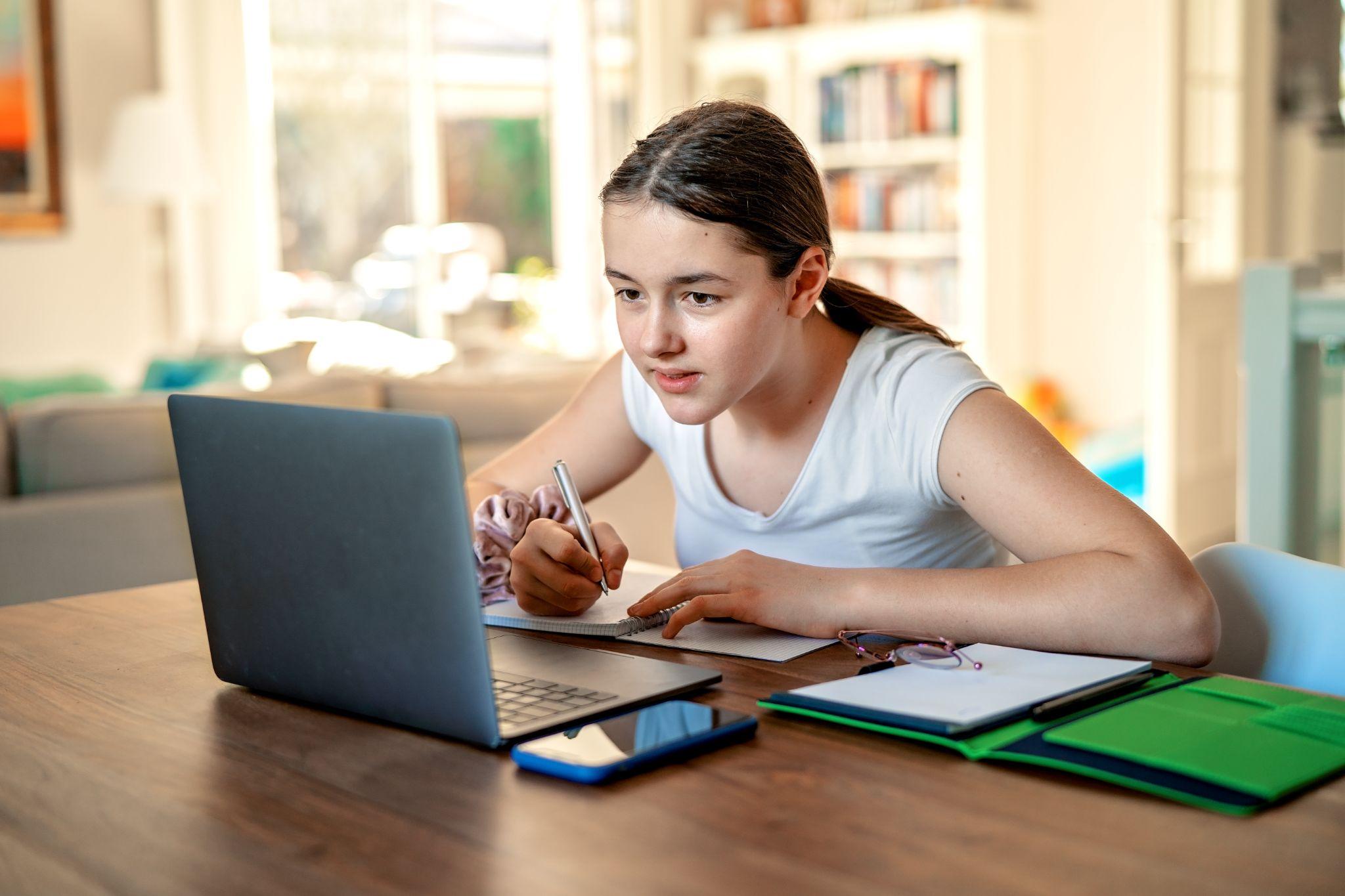 Teenager girl studying online at home