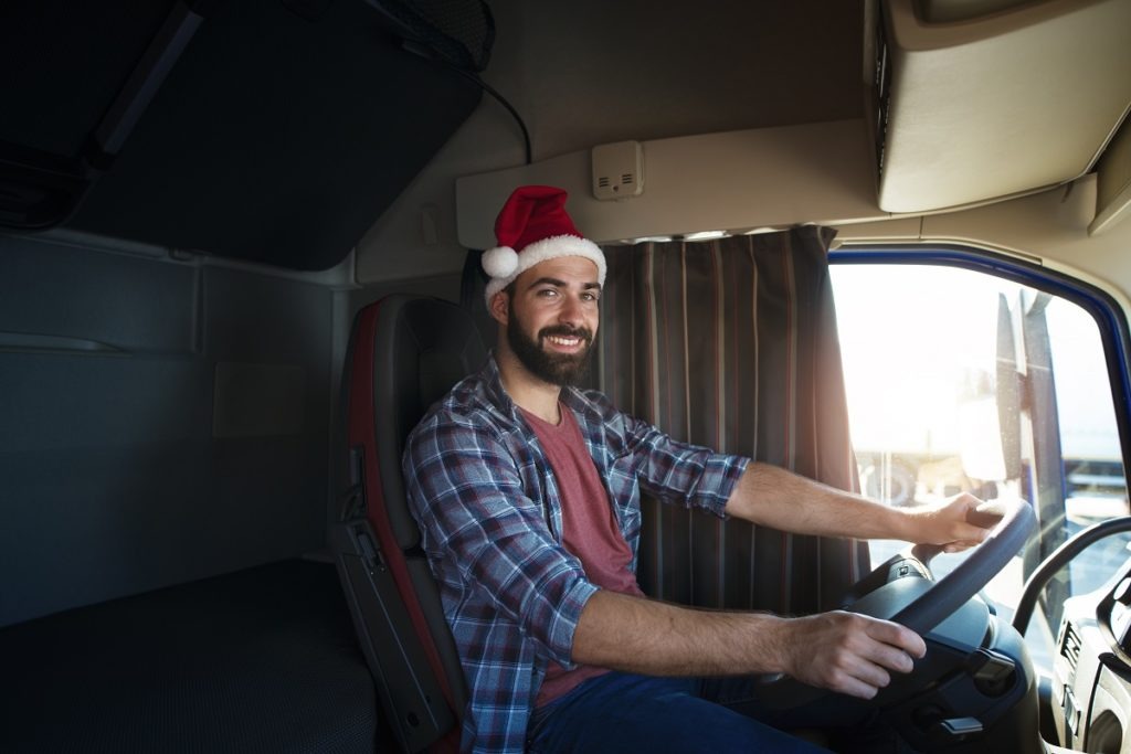 truck driver wearing santa clause hat and driving his truck