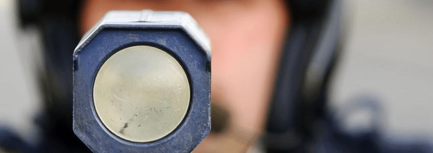 police officer holds his radar gun up at traffic.
