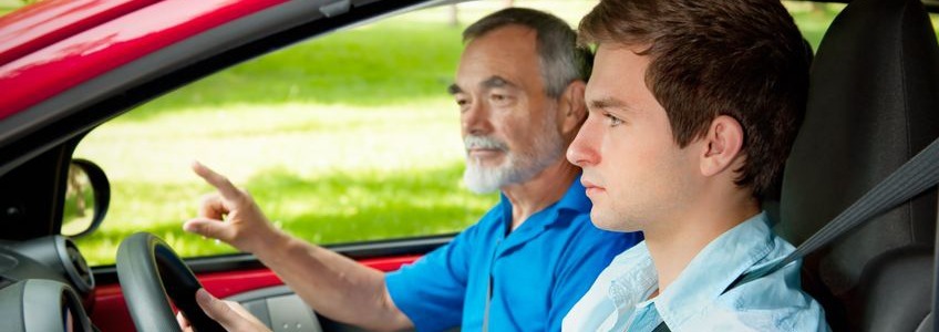 young man sitting in a car with a driving instructor