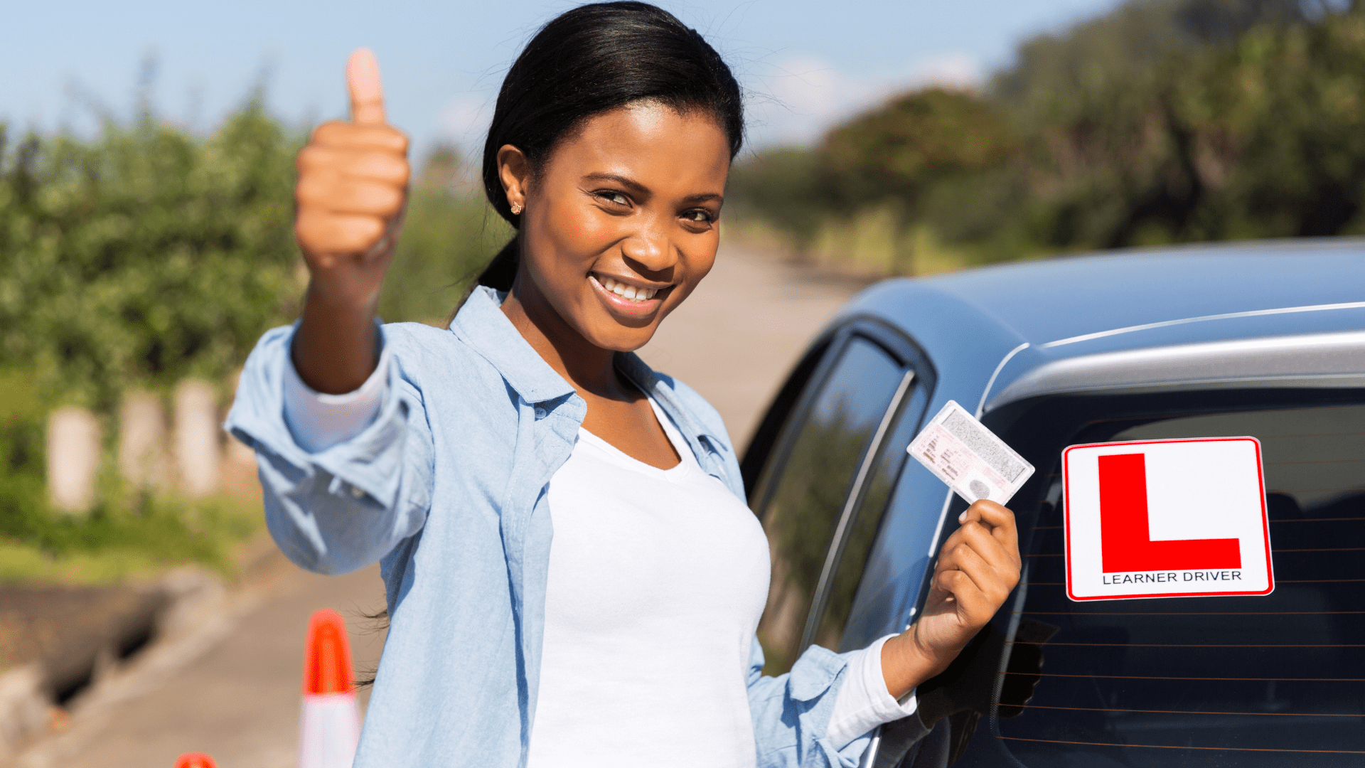 African learner driver holding her driver's license