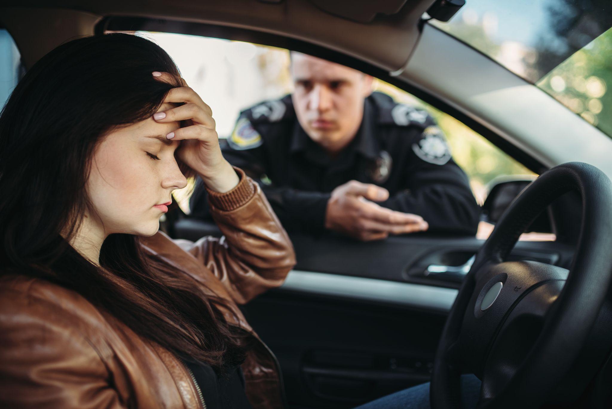 Male cop in uniform check female driver on road